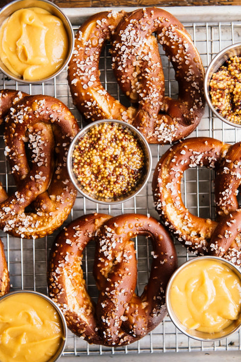 Load image into Gallery viewer, Assorted pretzels with mustard and spices on a cooling rack