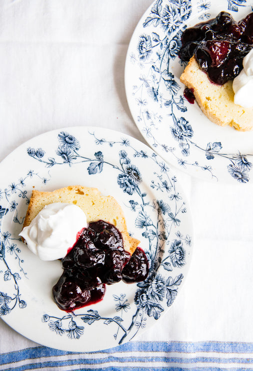 Load image into Gallery viewer, slices of pound cake on plates topped with homemade whipped cream and fruit perfect blueberries