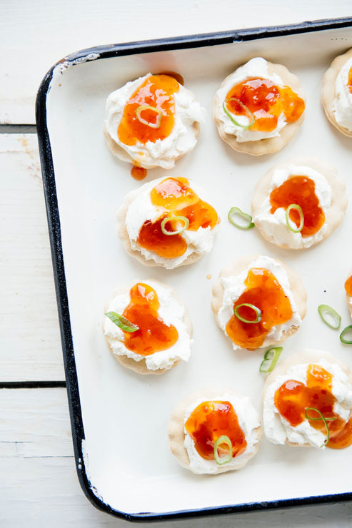 Load image into Gallery viewer, a tray of crackers topped with cream cheese and pepper jelly