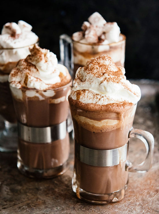 Load image into Gallery viewer, four glass mugs of hot cocoa topped with whipped cream