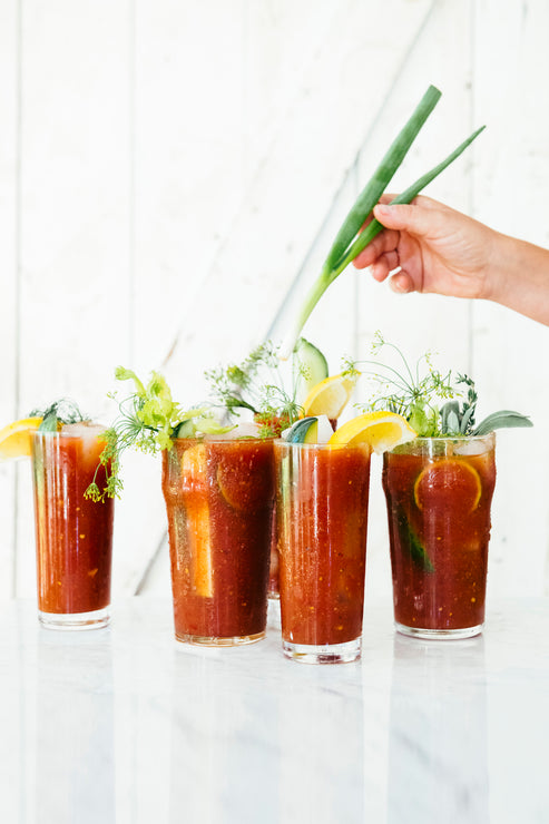 Load image into Gallery viewer, Someone garnishing glasses of bloody marys