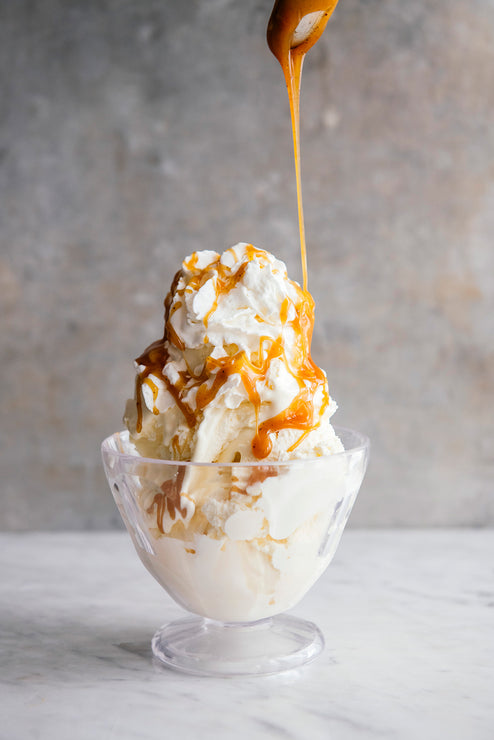 Load image into Gallery viewer, a bowl of vanilla ice cream and whipped cream topped with caramel
