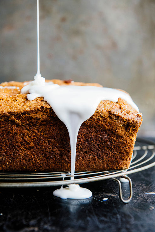Load image into Gallery viewer, a loaf of pumpkin bread topped with frosting