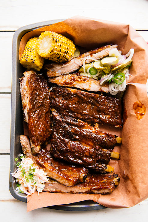 Load image into Gallery viewer, A rack of ribs with homemade pickles and corn on the cob