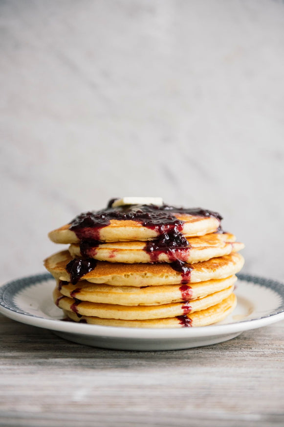 a stack of pancakes topped with fruit compote