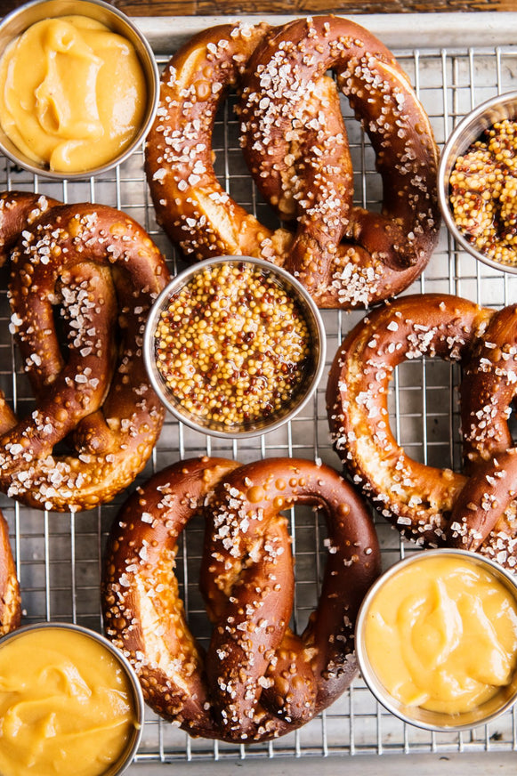 Assorted pretzels with mustard and spices on a cooling rack