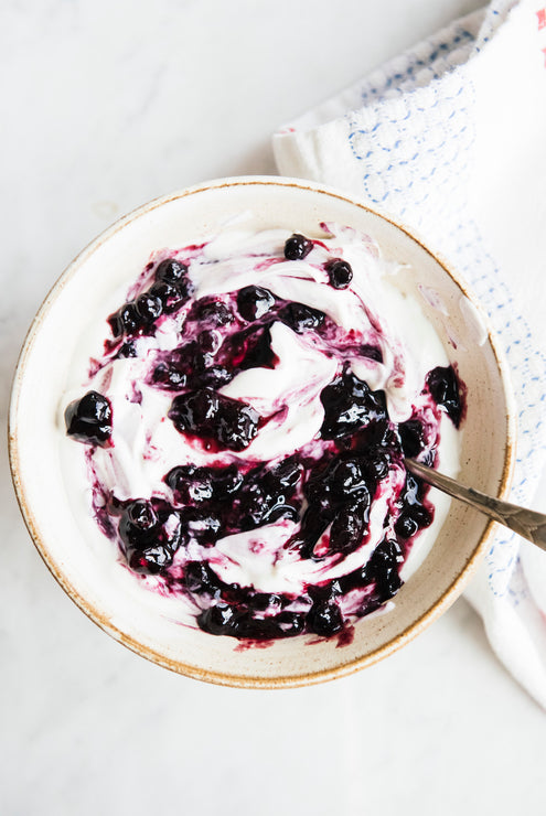 Load image into Gallery viewer, a bowl of yogurt with blueberry compote mixed throughout
