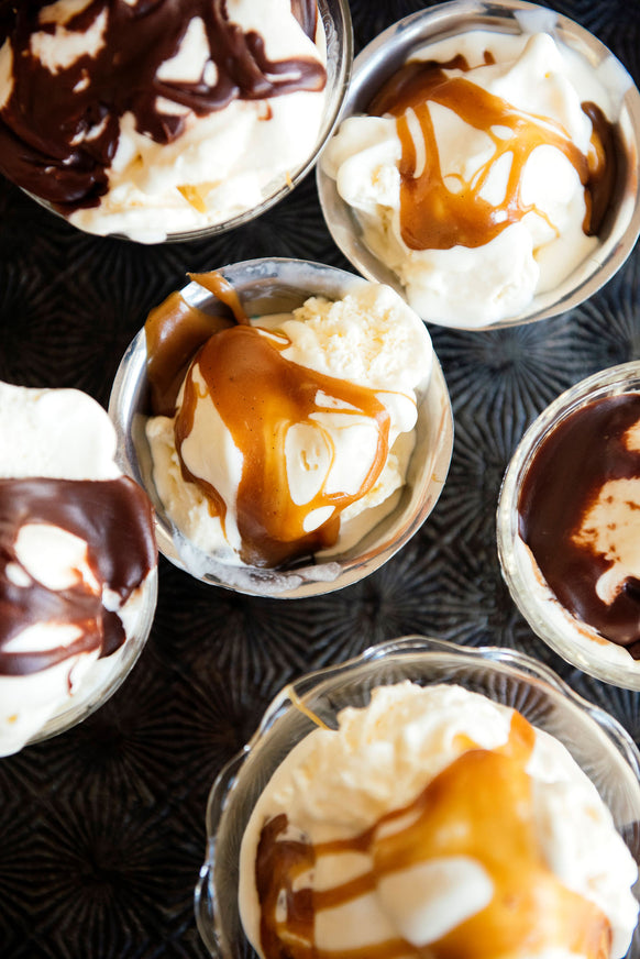 bowls of vanilla ice cream topped with salted maple caramel and chocolate fudge sauce