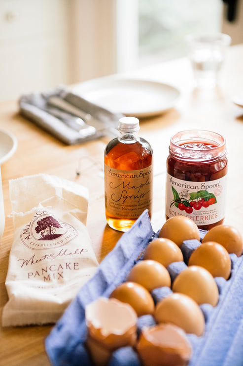 Load image into Gallery viewer, Kitchen table with carton of eggs, bottle of Maple Syrup, Fruit Perfect Sour Cherries and an open bag of pancake mix.
