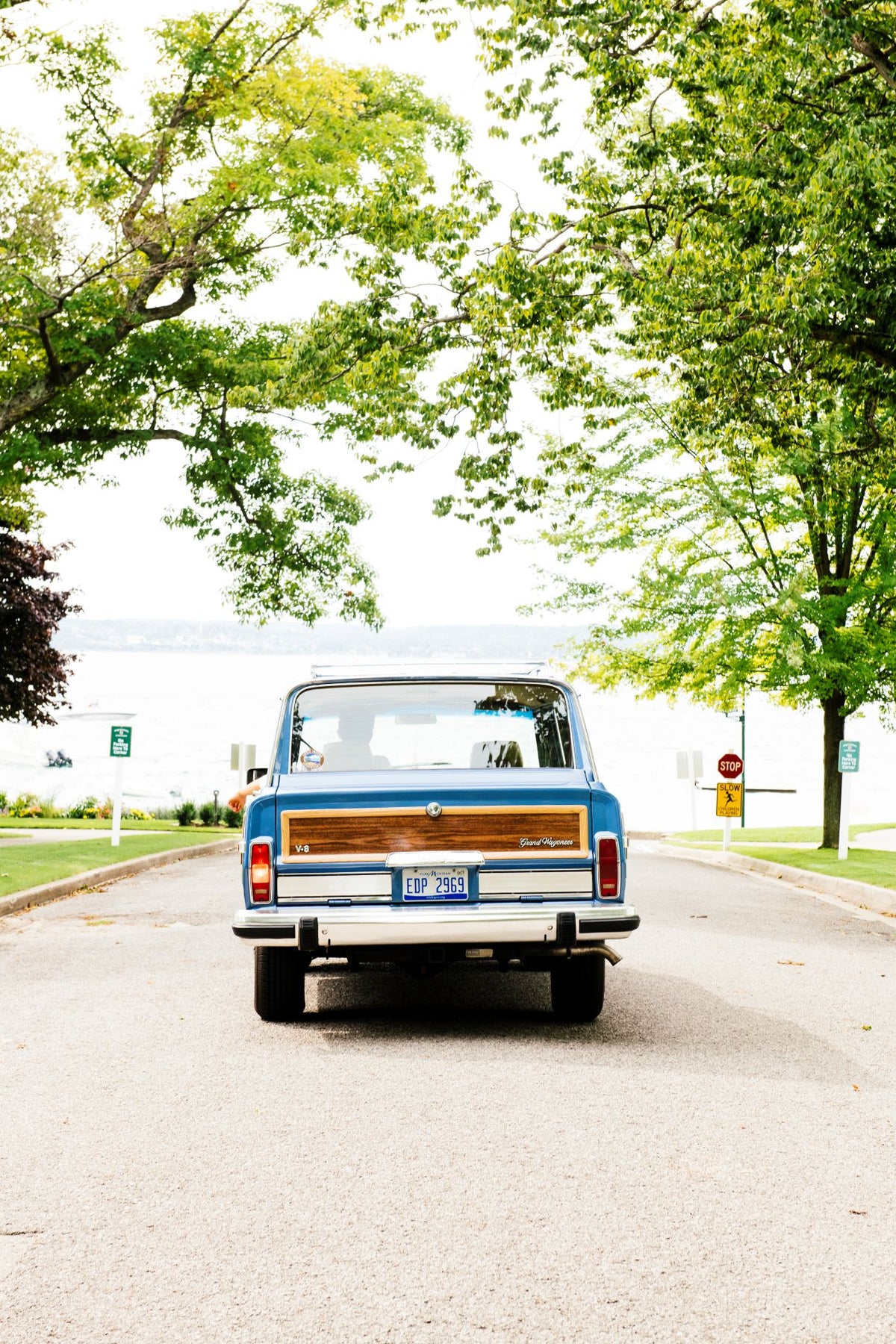 A blue Jeep Grand Wagoneer in front of Little Traverse Bay