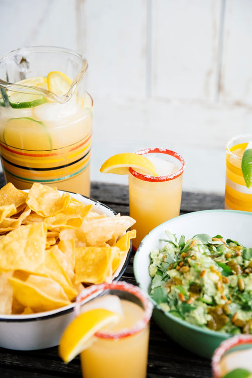 Load image into Gallery viewer, a bowl of homemade guacamole and chips next to a pitcher of margaritas
