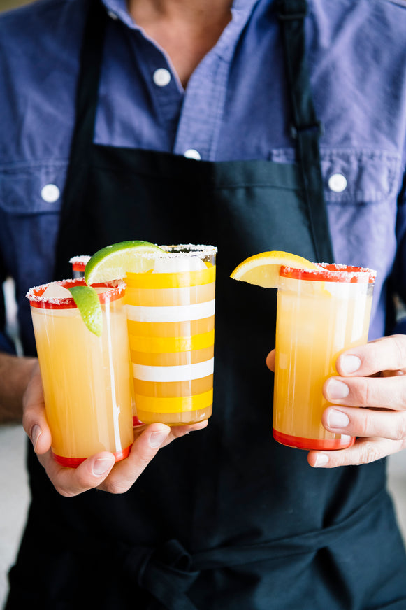 A man holding glasses of homemade margaritas