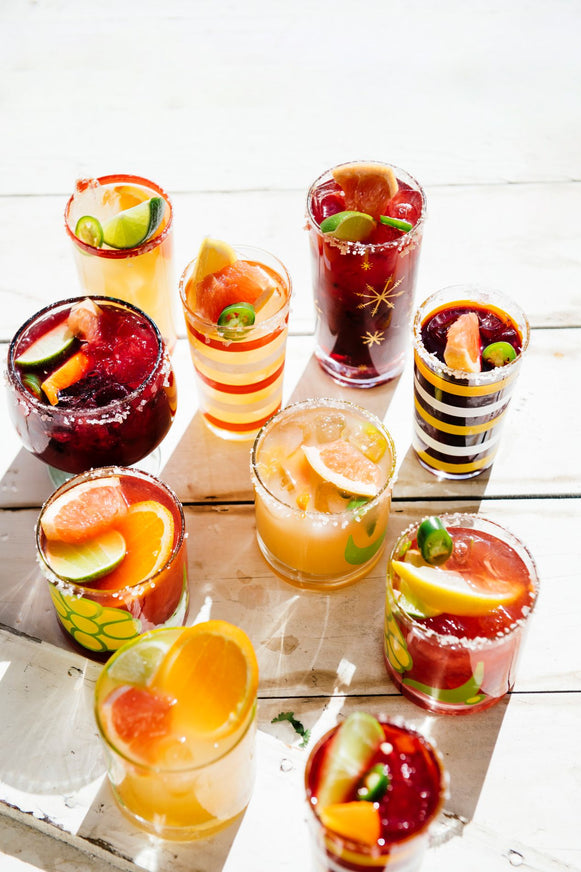 glasses of homemade cocktails with fresh fruit garnishes