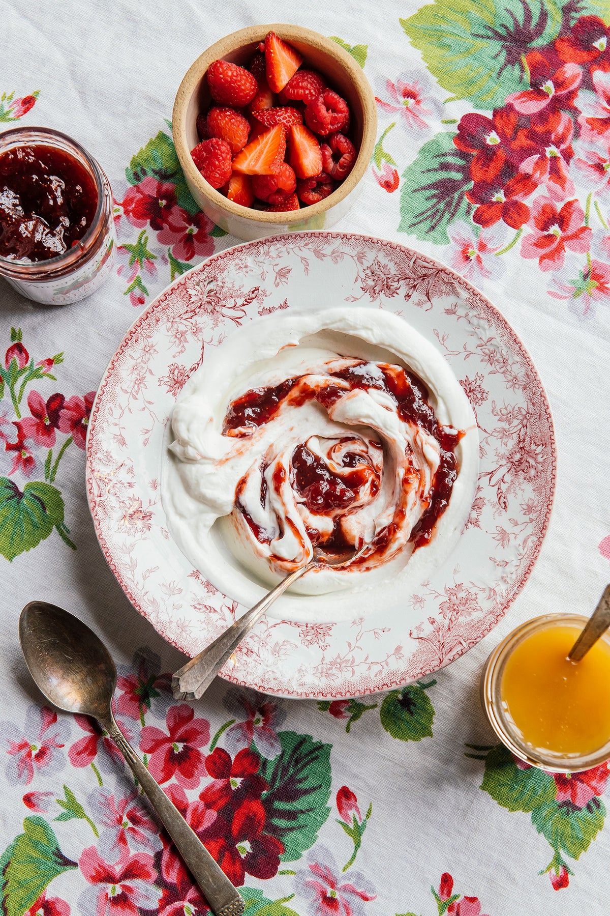 a bowl of yogurt topped with strawberry preserves and fresh strawberries