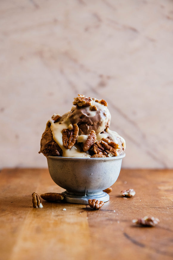 an ice cream sundae topped with salted maple caramel and pecans