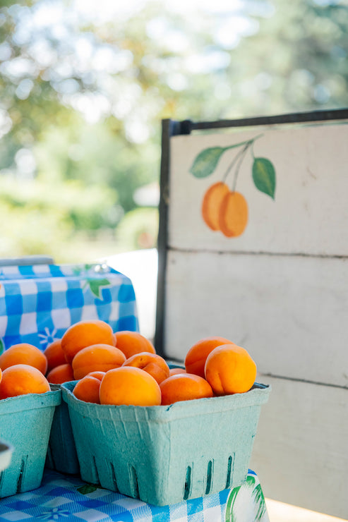 Load image into Gallery viewer, quart containers of apricots at the farmers market
