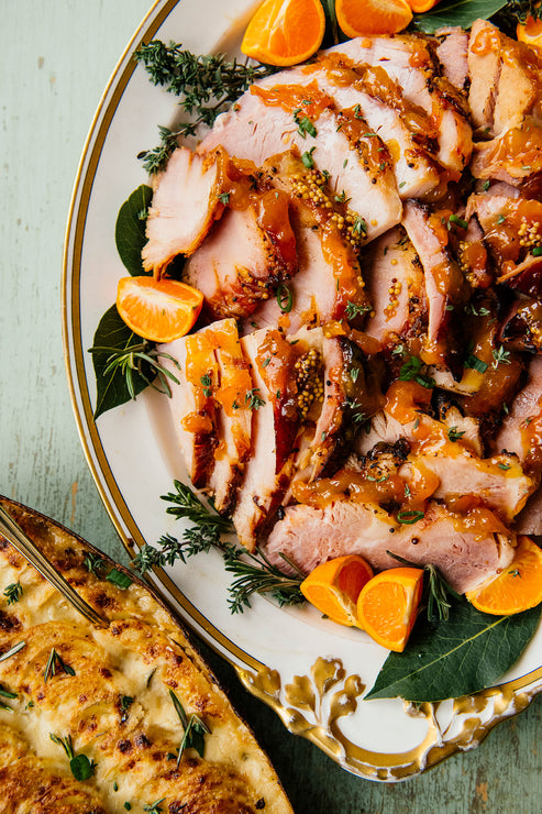 Load image into Gallery viewer, Orange Marmalade glazed ham on a platter with orange garnishes
