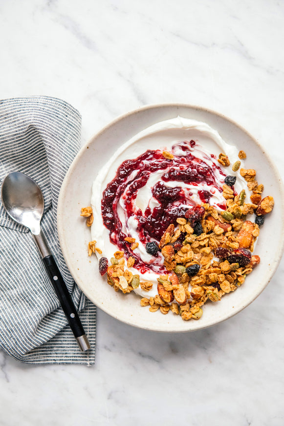 a bowl of yogurt topped with granola and preserves