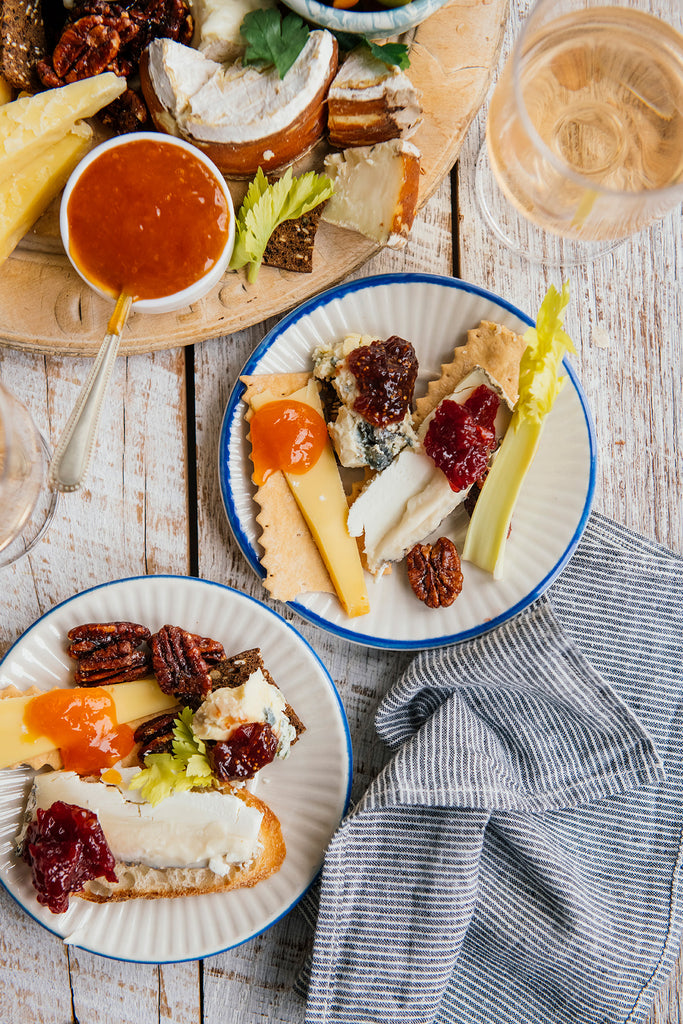 a charcuterie tray of cheeses, crackers, olives, candied pecans and various preserves and jams