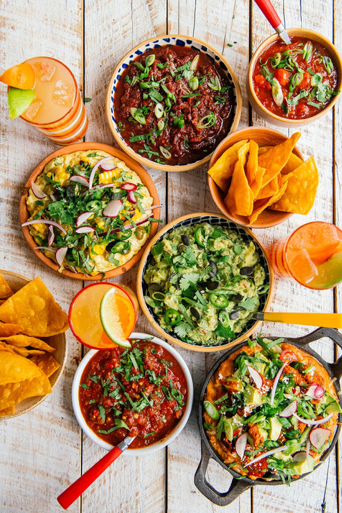 Load image into Gallery viewer, bowls of salsa, chips, guacamole, bean dip and street corn dip
