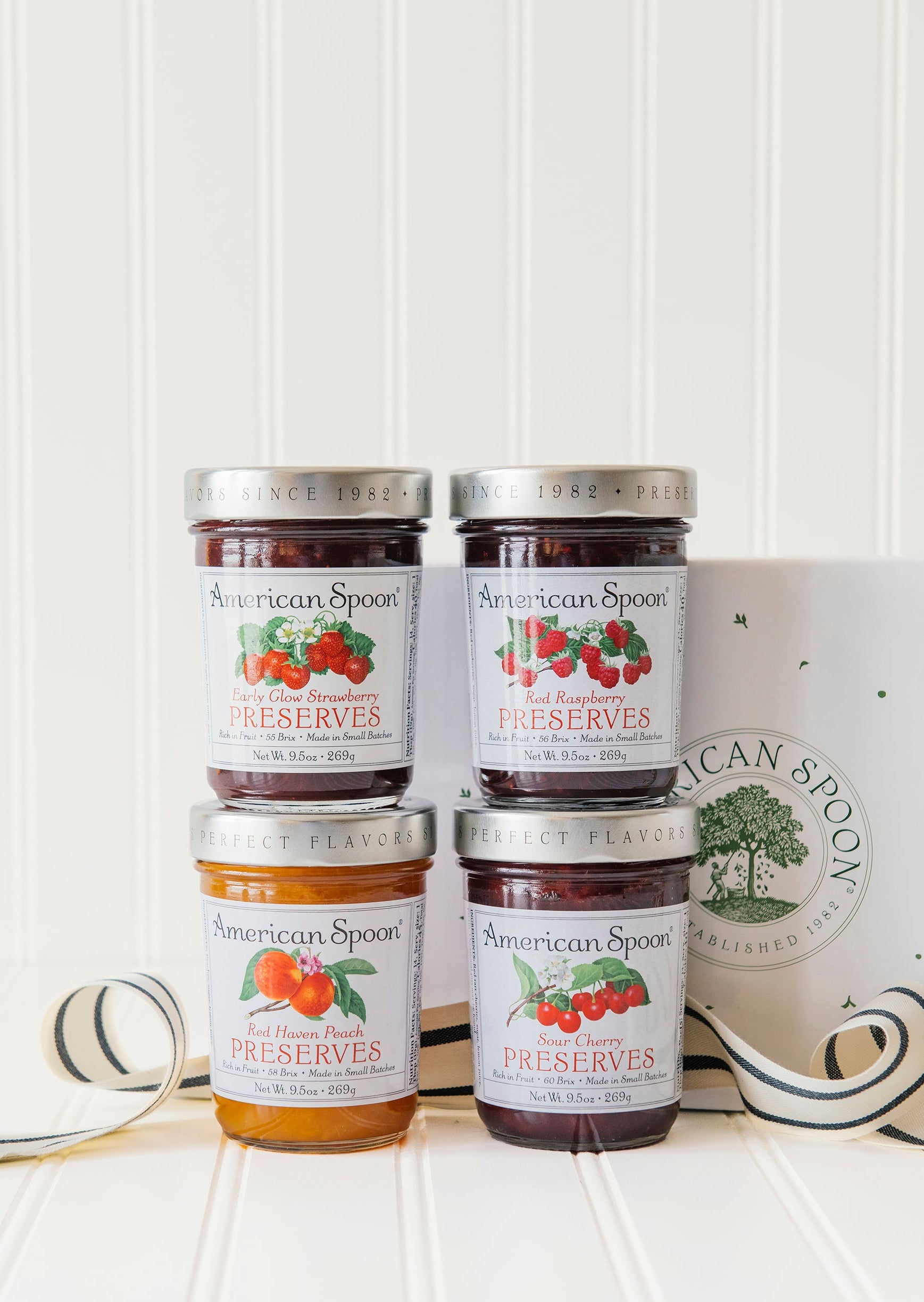 The preserve quartet gift box including early glow strawberry preserves, sour cherry preserves, red haven peach preserves, red raspberry preserves and a gift box