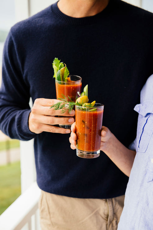 Load image into Gallery viewer, two people with glasses of bloody mary mix on a porch
