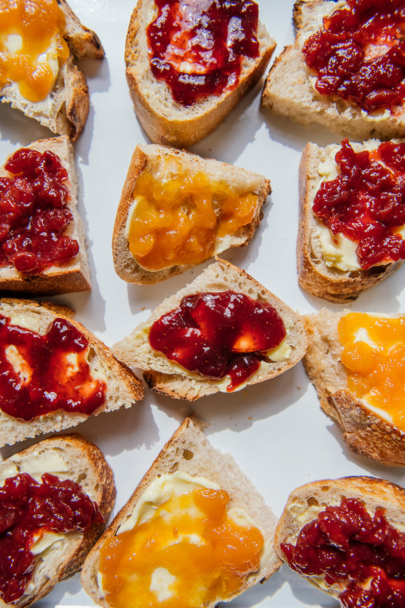 Toast slices with different types of jams on a white background