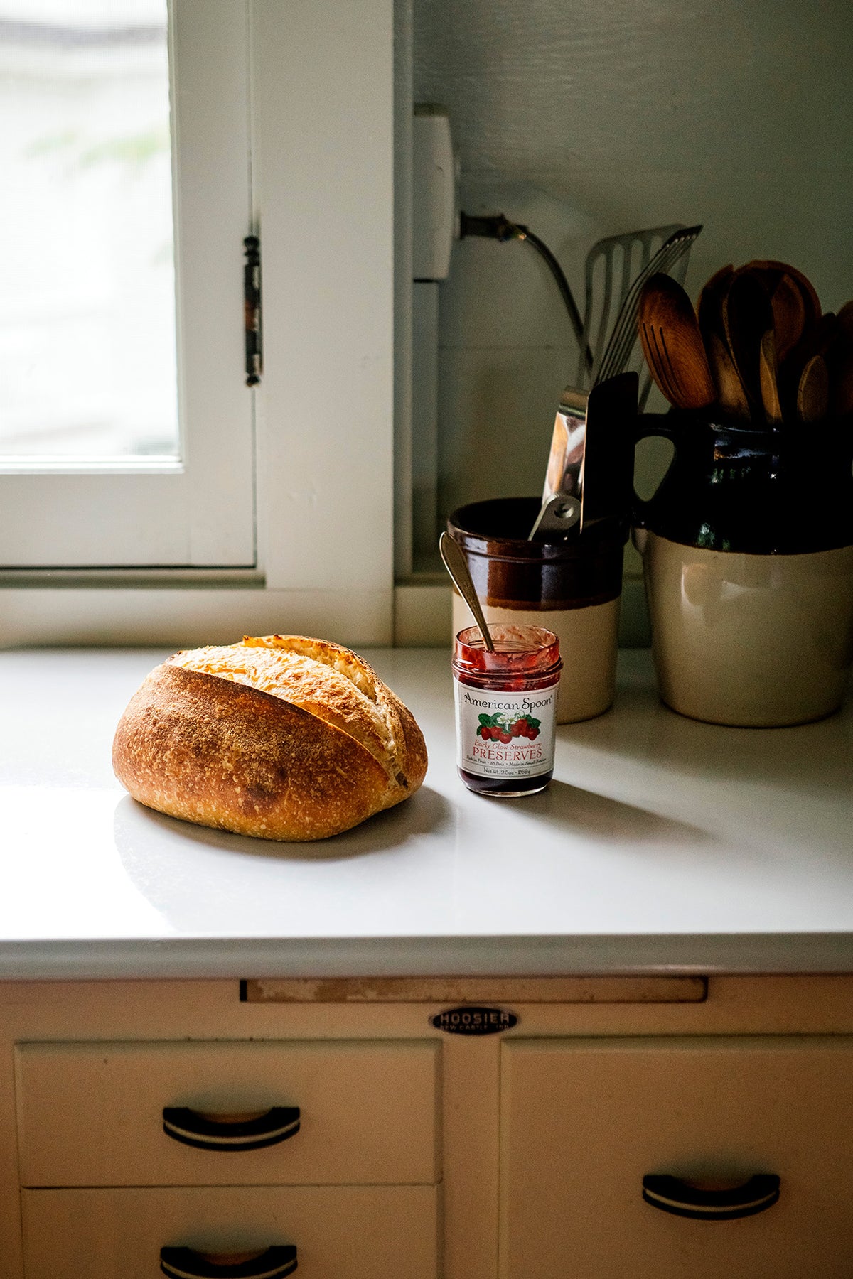 Loaf of bread with a jar Strawberry Preserves on a counter top