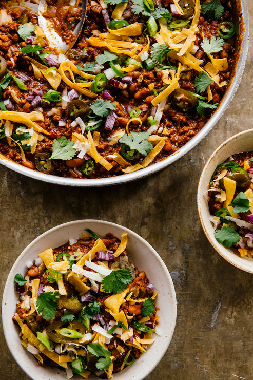 Load image into Gallery viewer, a large pot of chili made with cherry peach salsa and pumpkin chipotle roasting sauce topped with cheese, cilantro, onion and jalapenos
