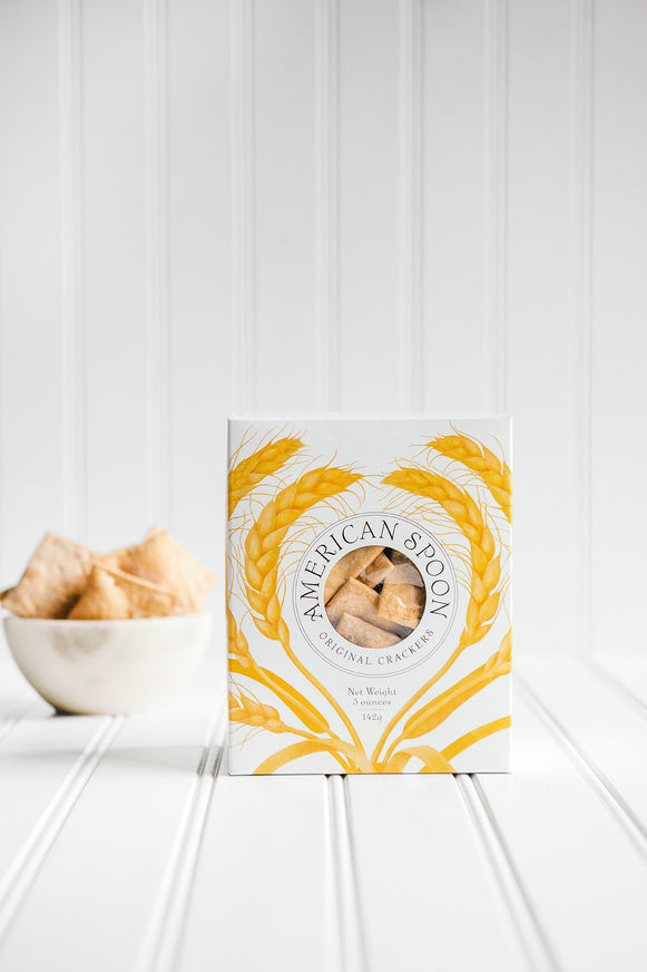 American Spoon original crackers box on a white surface with a bowl of crackers in the background
