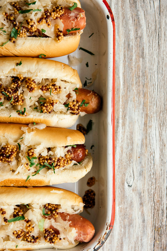 Hot dogs topped with sauerkraut and Whole Seed Mustard