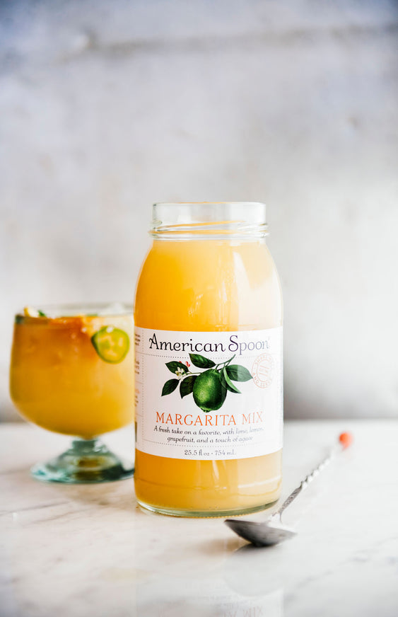 A jar of Margarita Mix with a cocktail in the background