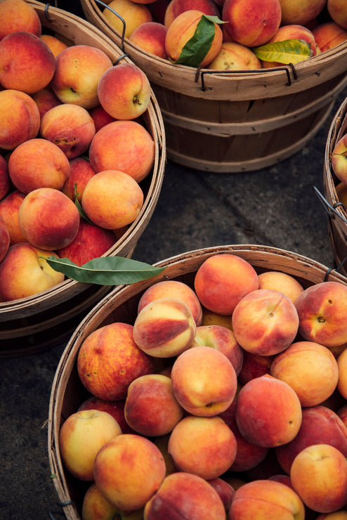 Load image into Gallery viewer, Bushels of ripe peaches
