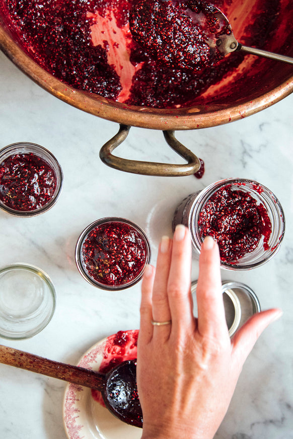 Filling jars of Red Raspberry Butter from a copper kettle