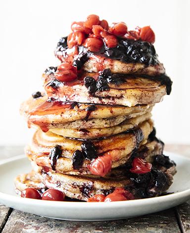 A stack of pancakes topped with Fruit Perfect Sour Cherries and Blueberries
